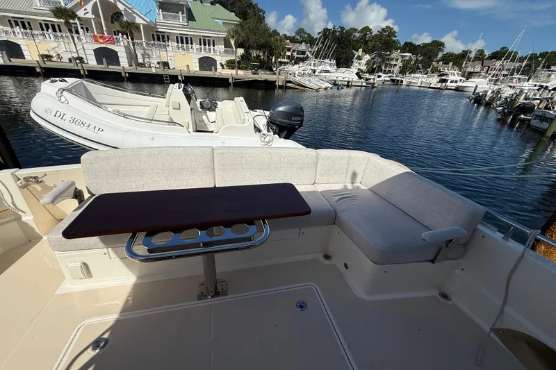 Slide: The Image of 2023 Sabre 43 Salon Express yacht with outdoor seating and table, docked at marina. - 34