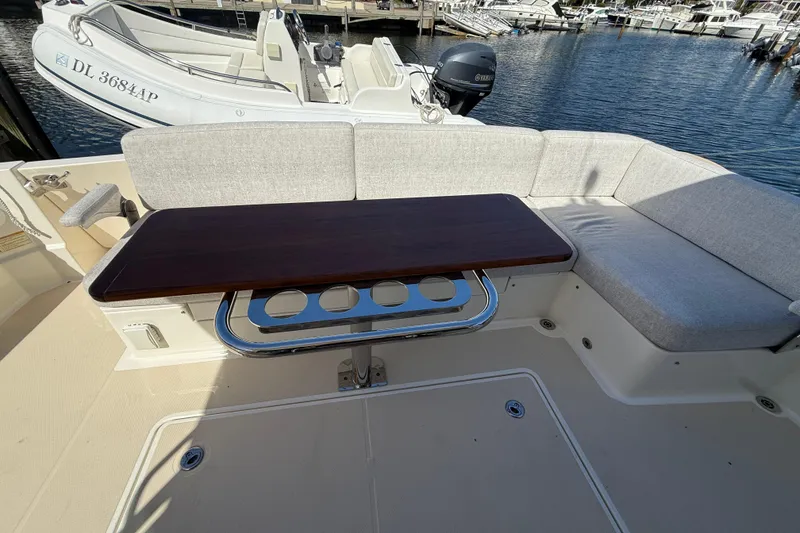 Slide: The Image of 2023 Sabre 43 Salon Express yacht interior with cushioned seating and wooden table. - 35