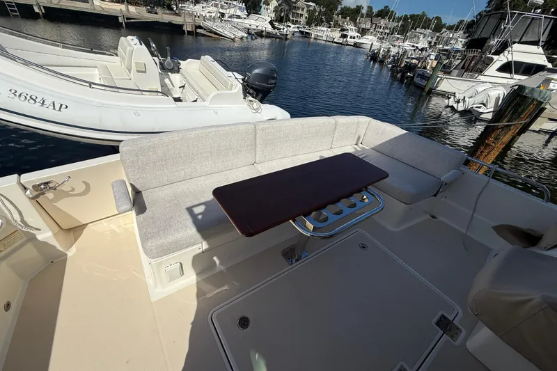 Slide: The Image of 2023 Sabre 43 Salon Express yacht with outdoor seating and table at marina. - 36