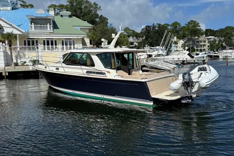 Slide: The Image of 2023 Sabre 43 Salon Express yacht docked in a marina, surrounded by other boats. - 4