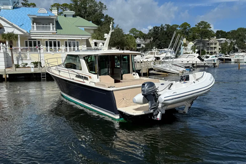 Slide: The Image of 2023 Sabre 43 Salon Express yacht docked at a marina with a tender boat. - 5