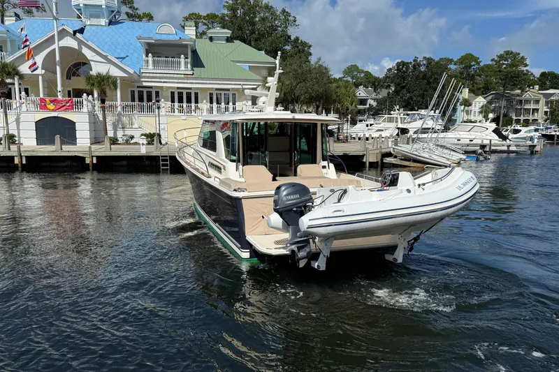 Slide: The Image of 2023 Sabre 43 Salon Express yacht docked at a marina with a tender boat. - 6