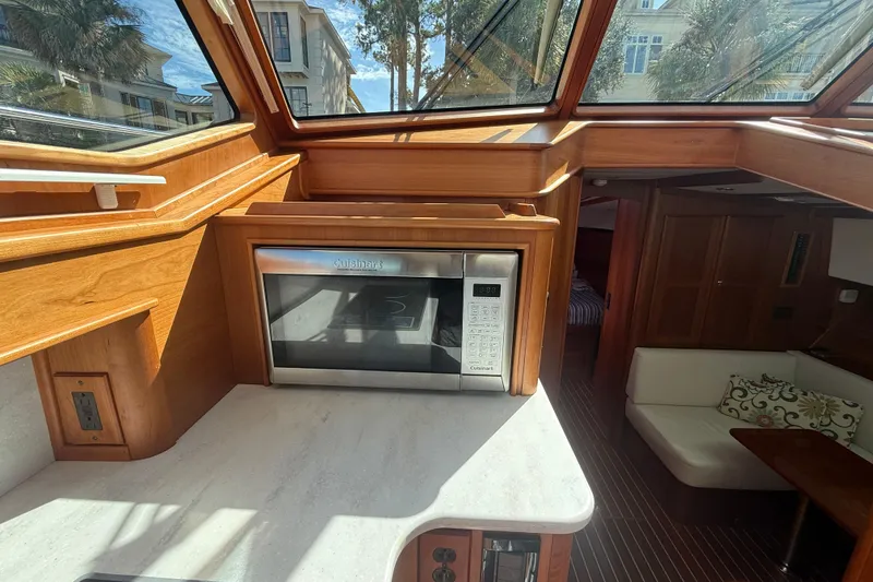 Slide: The Image of 2023 Sabre 43 Salon Express interior with microwave, wood finish, and seating area. - 68
