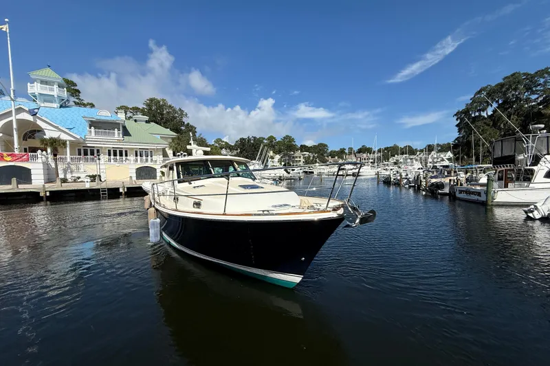 Slide: The Image of 2023 Sabre 43 Salon Express yacht docked at a marina under a clear blue sky. - 8