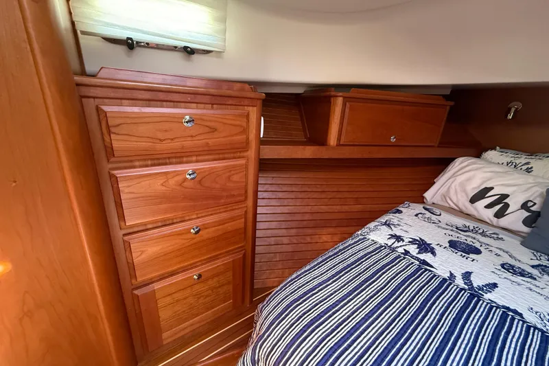 Slide: The Image of 2023 Sabre 43 Salon Express cabin with wooden cabinetry and cozy bedding. - 84