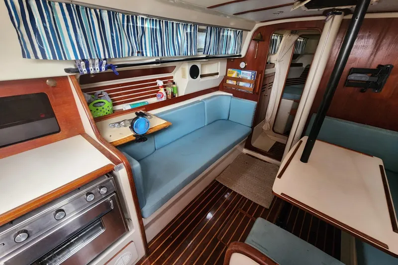 Slide: The Image of Open storage compartment on 1982 Pearson 323 sailboat, containing ropes and a metal cylinder. - 26