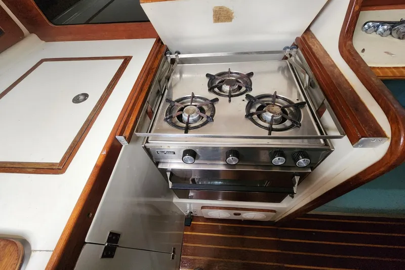 Slide: The Image of Interior of a 1982 Pearson 323 sailboat featuring a compact kitchen and seating area. - 32