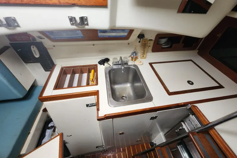 Slide: The Image of Interior of 1982 Pearson 323 sailboat with cozy seating and striped curtains. - 34