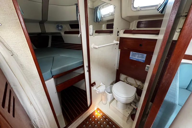 Slide: The Image of 1982 Pearson 323 yacht interior with cabin, toilet, and wooden accents. - 53