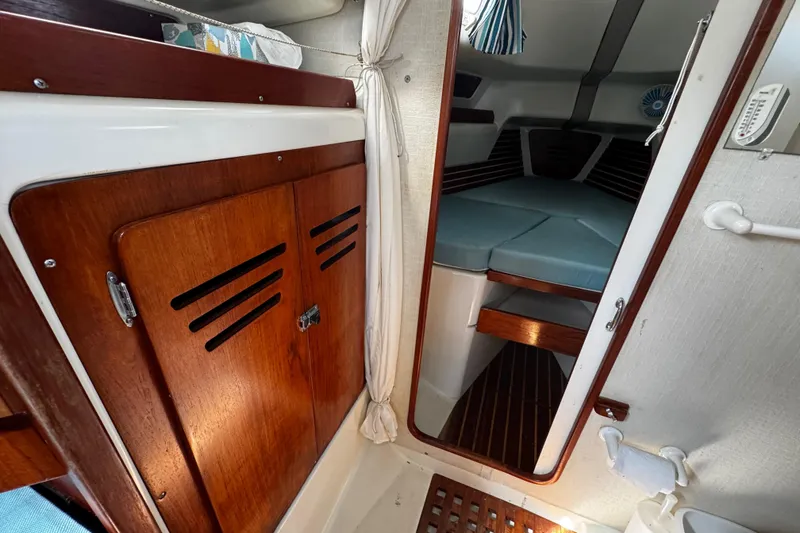 Slide: The Image of Interior of 1982 Pearson 323 sailboat with wooden cabinetry and cozy sleeping area. - 58
