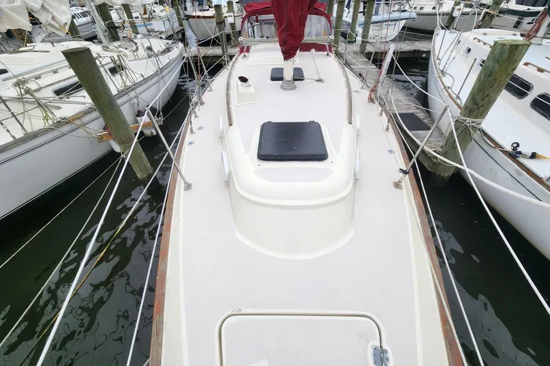 Slide: The Image of 1982 Pearson 323 sailboat docked, featuring a spacious cockpit and maroon accents. - 7