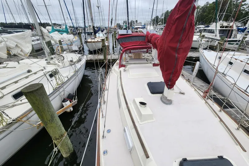 Slide: The Image of 1982 Pearson 323 sailboat with maroon canvas, docked in a marina. - 8