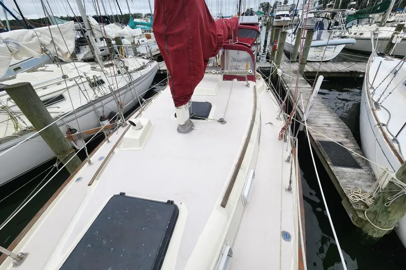 Slide: The Image of 1982 Pearson 323 sailboat docked in a marina, surrounded by other boats. - 9