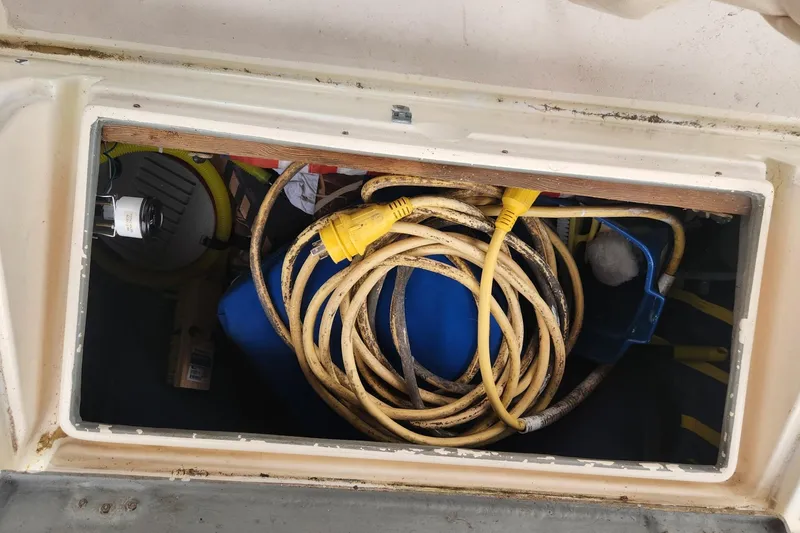 Slide: The Image of Storage compartment on 1982 Pearson 323 sailboat with coiled yellow power cable. - 21