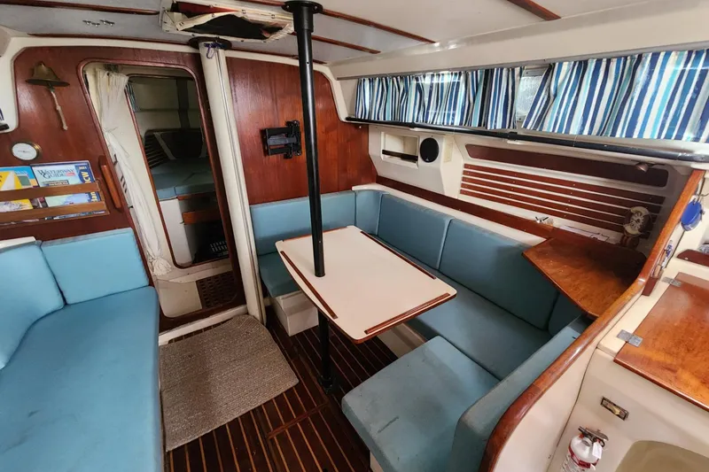 Slide: The Image of Interior of 1982 Pearson 323 sailboat with cozy seating and striped curtains. - 27