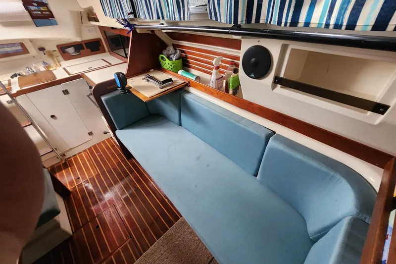 Slide: The Image of Interior of 1982 Pearson 323 sailboat with blue seating and wooden flooring. - 29
