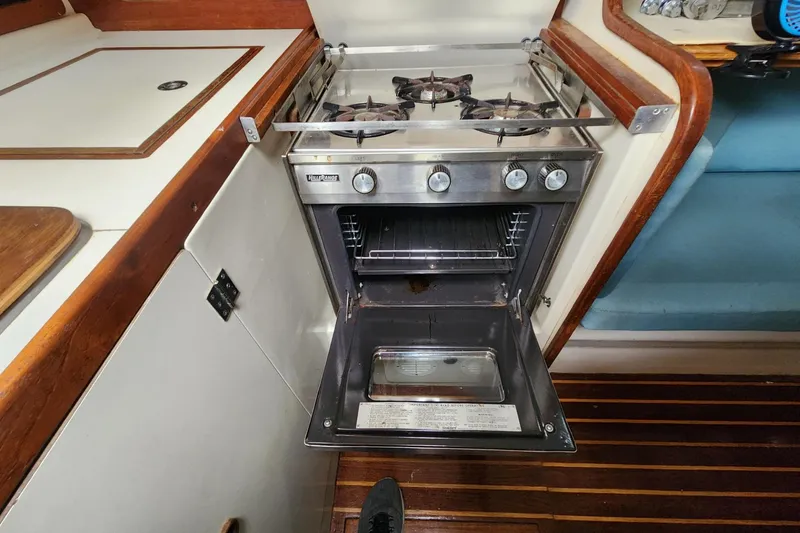 Slide: The Image of Pearson 323 sailboat kitchen with open oven and stove, 1982 model. - 33