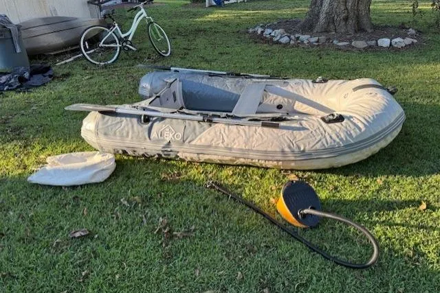 Slide: The Image of Inflatable Aleko boat on grass with pump and bicycle nearby. - 46