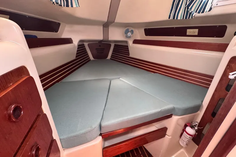 Slide: The Image of Cozy cabin interior of 1982 Pearson 323 sailboat with cushioned berth and wood accents. - 59