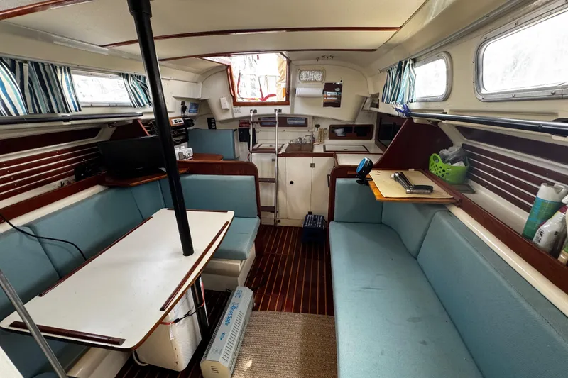 Slide: The Image of Interior of a 1982 Pearson 323 sailboat with blue seating and wooden accents. - 63