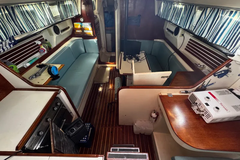 Slide: The Image of Interior of a 1982 Pearson 323 sailboat with striped curtains and wooden finishes. - 72