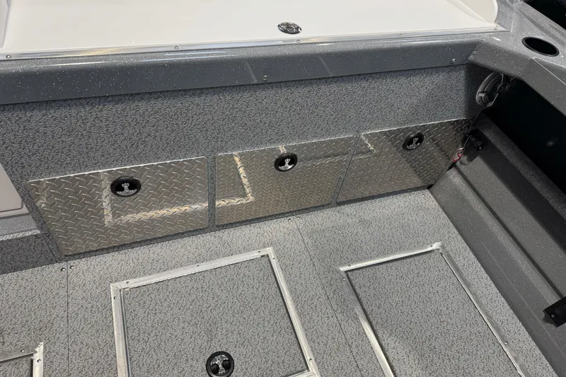 Slide: The Image of 2026 Lund 200 Heavy Gauge boat interior with diamond plate storage compartments. - 16