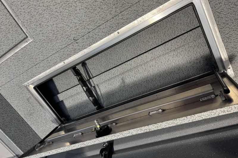 Slide: The Image of 2026 Lund 200 Heavy Gauge boat storage compartment with open hatch, showcasing interior details. - 19