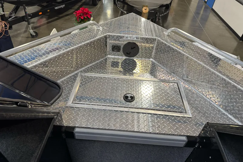 Slide: The Image of 2026 Lund 200 Heavy Gauge boat with diamond plate flooring in showroom. - 28
