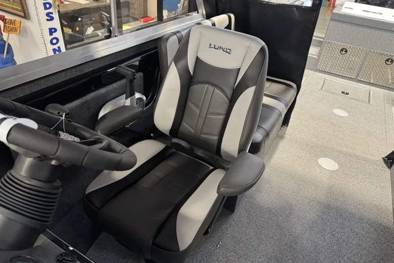 Slide: The Image of 2026 Lund 200 Heavy Gauge boat interior with steering wheel and cushioned seats. - 33