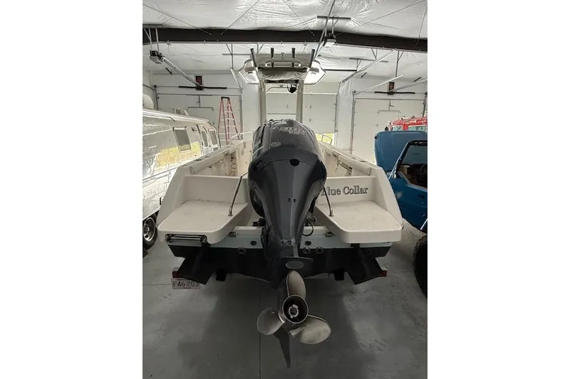 Slide: The Image of 2013 Everglades 230 Center Console boat in a garage, rear view with outboard motor. - 10
