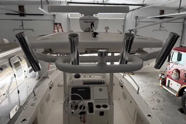 Slide: The Image of 2013 Everglades 230 Center Console boat interior with fishing rod holders and navigation equipment. - 29