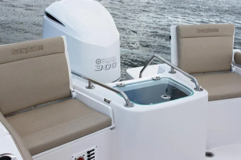 Slide: The Image of 2013 Everglades 230 Center Console boat in a garage, featuring a powerful outboard motor. - 8