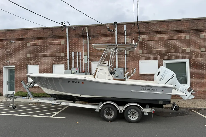 The Image of 2023 Pioneer 220 Bay Sport boat on trailer, parked by a brick building. - 0