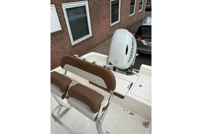Slide: The Image of 2023 Pioneer 220 Bay Sport boat with Suzuki outboard motor and cushioned seating. - 18