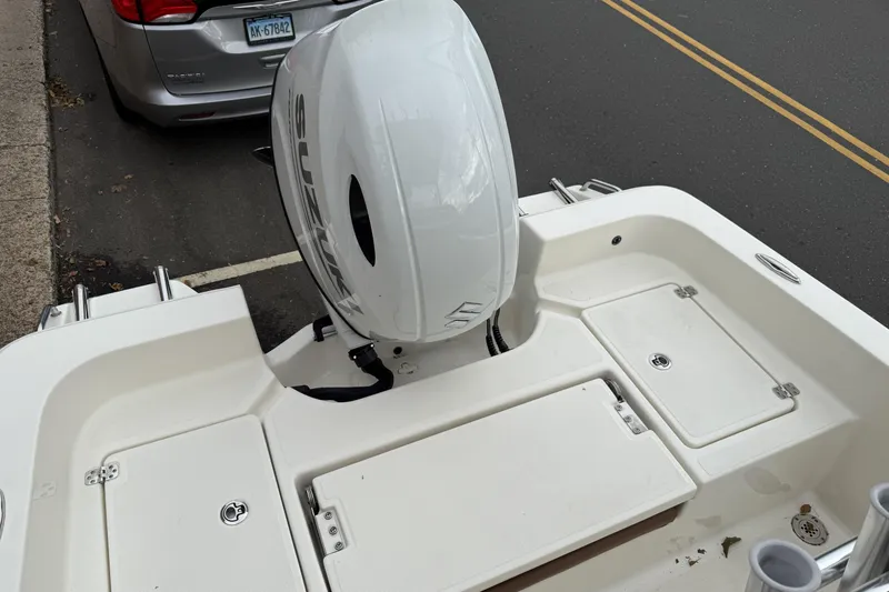 Slide: The Image of 2023 Pioneer 220 Bay Sport boat with Suzuki outboard motor, parked on street. - 9