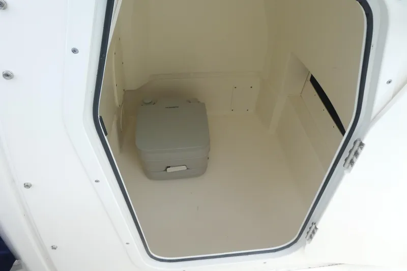 Slide: The Image of 2024 Boston Whaler 220 Dauntless interior storage compartment with portable toilet. - 13
