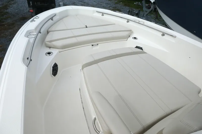 Slide: The Image of 2024 Boston Whaler 220 Dauntless boat interior with cushioned seating and stainless steel railings. - 9