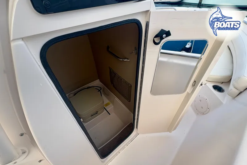 Slide: The Image of 2015 Grady-White Fisherman 209 boat interior with open storage compartment and portable toilet. - 7