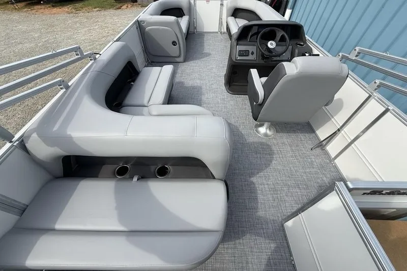 Slide: The Image of 2026 Sun Tracker Party Barge 18 DLX interior with gray seating and steering console. - 28