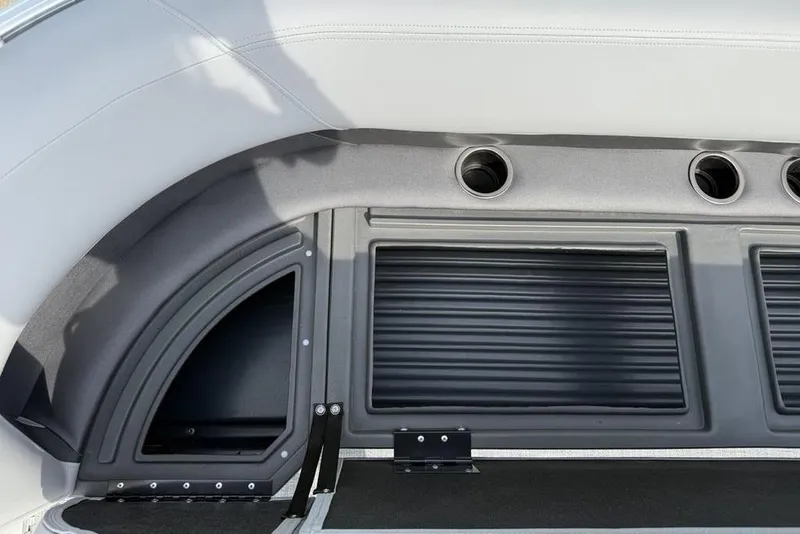 Slide: The Image of 2026 Sun Tracker Party Barge 18 DLX interior detail with cup holders and storage compartments. - 6