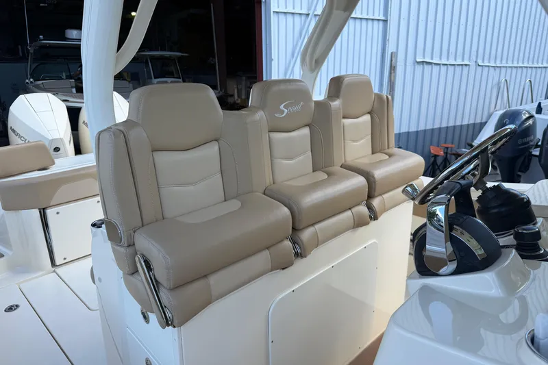 Slide: The Image of 2022 Scout 355 LXF boat interior with beige leather seating and steering wheel. - 15