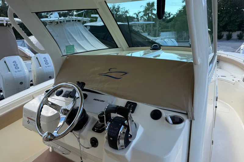 Slide: The Image of 2022 Scout 355 LXF boat helm with Mercury controls and covered dashboard. - 16