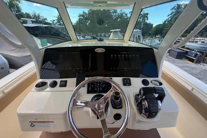 Slide: The Image of 2022 Scout 355 LXF boat helm with modern controls and steering wheel. - 17
