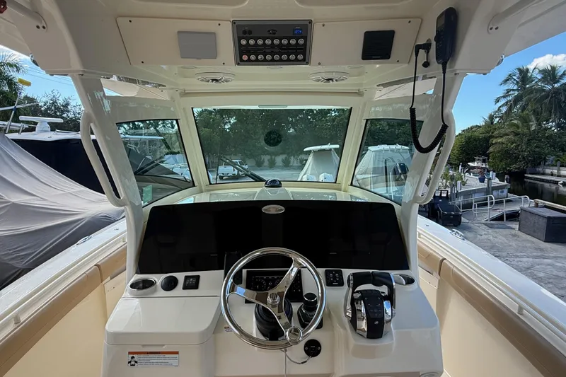 Slide: The Image of 2022 Scout 355 LXF boat helm with steering wheel and controls. - 19