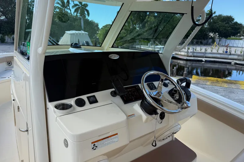 Slide: The Image of 2022 Scout 355 LXF boat helm with steering wheel and control panel. - 20