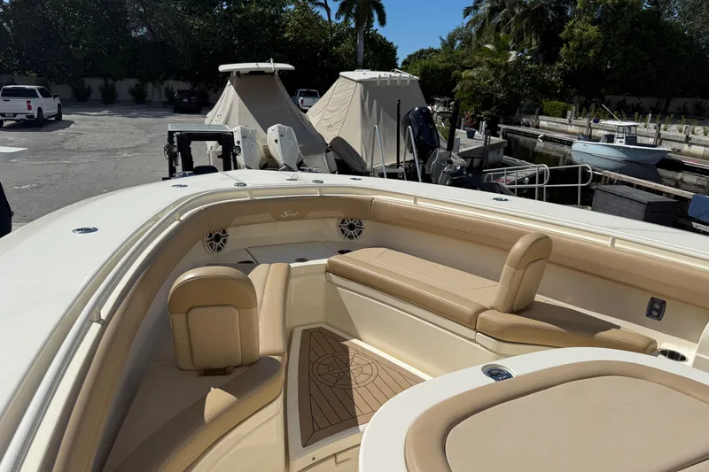 Slide: The Image of 2022 Scout 355 LXF boat interior with beige seating and wood accents. - 27