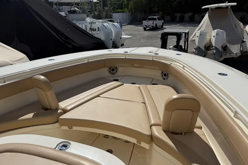 Slide: The Image of 2022 Scout 355 LXF boat with tan seating and sleek design in a marina setting. - 29