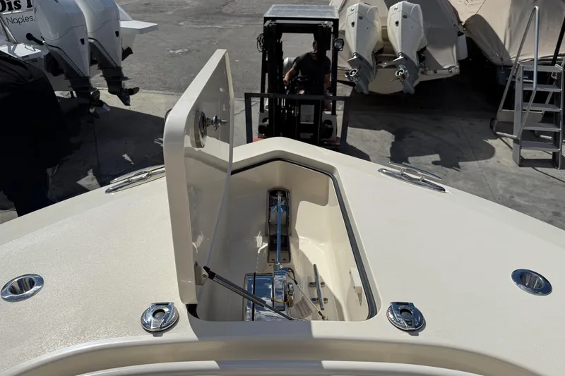 Slide: The Image of 2022 Scout 355 LXF boat anchor compartment with open hatch, docked at marina. - 33