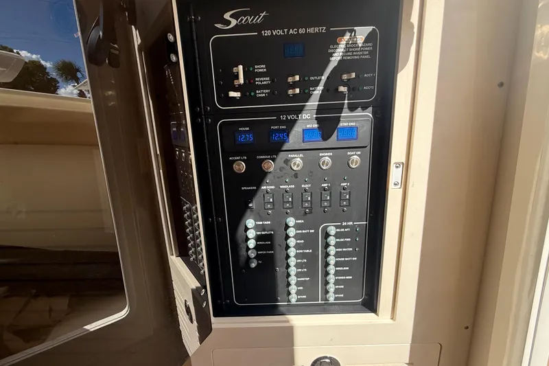 Slide: The Image of Electrical control panel on 2022 Scout 355 LXF boat, featuring various switches and displays. - 41