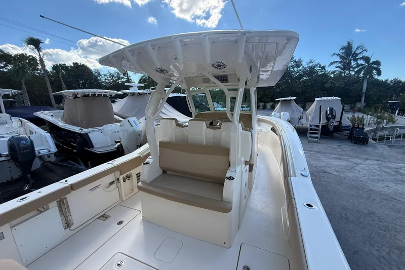 Slide: The Image of 2022 Scout 355 LXF boat with seating and canopy, docked under a clear sky. - 8